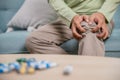 Old man suffering from knee joint pain on sofa living room Royalty Free Stock Photo