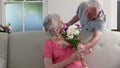 Old man surprising his wife with gifts