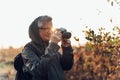 Old man taking photo in nature. Mature man taking pictures of the forest in fall Royalty Free Stock Photo