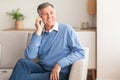 Old Man Talking On Cellphone Sitting On Sofa At Home Royalty Free Stock Photo