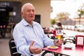 Old man talking with someone on restaurant terrace Royalty Free Stock Photo