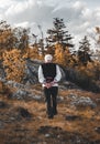 Old man in traditional Slovak national folk costume walking through the forest mountains with rocks, trees and cloudy sky on Royalty Free Stock Photo