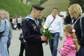 Old man in the uniform of Soviet Fleet sailor, taking flowers from little girl, celebrating the Victory Day
