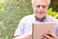 Old man using digital tablet.