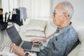 Old man using laptop computer on the sofa Royalty Free Stock Photo