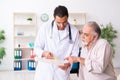 Old man visiting young male doctor cardiologist Royalty Free Stock Photo