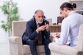 Old man visiting young male doctor psychologist Royalty Free Stock Photo
