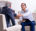 Old man visiting young male doctor psychologist Royalty Free Stock Photo