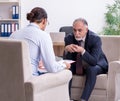 Old man visiting young male doctor psychologist Royalty Free Stock Photo