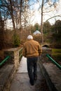 Old Man Walking Across a Bridge Outside Royalty Free Stock Photo