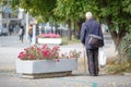 Old man walking with his hands on a wooden walking stick, natural Royalty Free Stock Photo