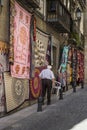 Old man walking in a street, multicolored fabric in a Granada street, Spain