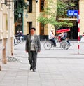 An old man walking on street at Old Town in Hanoi, Vietnam
