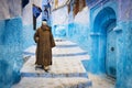 Old man walking in a street of the town of Chefchaouen in Morocco. Royalty Free Stock Photo