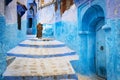 Old man walking in a street of the town of Chefchaouen in Morocco. Royalty Free Stock Photo