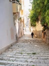 Old man walks down from steps in historical town