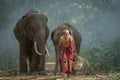 The old man was walking out of the forest with the elephant he raised