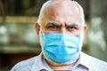 Old man wearing face mask. Portrait of an old man, years old, in a medical mask. Concept danger of coronavirus for the