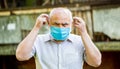 Old man wearing face mask. Portrait of an old man, years old, in a medical mask. Concept danger of coronavirus for the Royalty Free Stock Photo