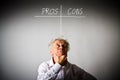 Old man is full of doubts and hesitation. Pros and cons concept. Royalty Free Stock Photo