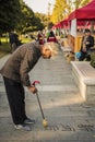 An old man writing Chinese calligraphy in the park