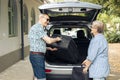 Old man and woman loading suitcase Royalty Free Stock Photo