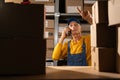 Old man worker talking on a mobile phone to checking inventory in the warehouse store Royalty Free Stock Photo