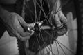 The old man working on motorcycle tire with tools close view in a service shop using finger in hands Royalty Free Stock Photo