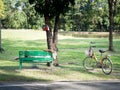 The old man with wrist watch and wearing a white cowboy hat was resting on a green chair in the garden. There are old yellow bike Royalty Free Stock Photo