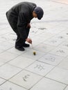 Old man writing chinese handwriting on the floor