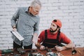 Old Manager Checking Motherboard near Worker. Royalty Free Stock Photo