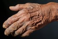 an old mans hand on a black background