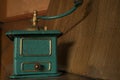 Old manual coffee grinder painted gold and green