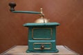 Old manual coffee grinder painted gold and green