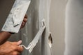 Old manual worker with wall plastering tools renovating house.