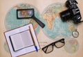 Old map of the hemispheres on it a camera, clock, magnifier and a notebook Royalty Free Stock Photo