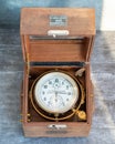 An old marine chronometer in a wooden case