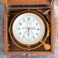 An old marine chronometer in a wooden case