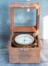 An old marine chronometer in a wooden case