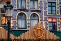 Old Markt Square in Brugge, Belgium. Christmas decorations on the building and a metal lamp in focus. Royalty Free Stock Photo