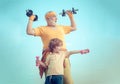 Old mature man and little boy exercising with dumbbell. Grandfather and child lifting weights. Be in motion. Like sports