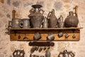 Old measures for oil on a wooden shelf attached to a stone wall Royalty Free Stock Photo