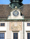 Old Mechanical and Sundial Clock on the roof and facade of a palace in Vienna, Austria