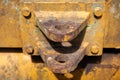 Old mechanism detail, yellow painted special equipment closeup photo. Truck or tractor trailer connector