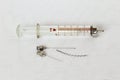 Old medical rare glass reusable syringe, metal needles and mandrin on white gauze. Retro. Black and white photo