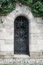 Old medieval black metal door with cerved bar and Royalty Free Stock Photo