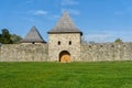 Old medieval castle wall with tower and big grass field Royalty Free Stock Photo