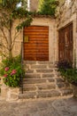 Old medieval city. Ancient European courtyard, stone stairs and old wooden gates doors to a residential building