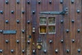 Old medieval door with metal trim and small peephole window.