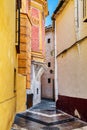 Old medieval narrow street with Spanish style colorful facades of buildings and blue sky in the background Royalty Free Stock Photo